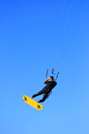 A kitesurfer in midair on blue backgroundの写真素材