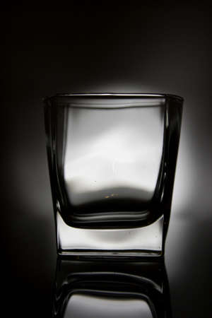 Whiskey glass surrounded by black except for white centreの写真素材