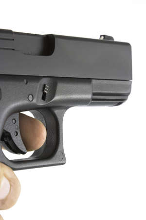 Handgun being aimed with finger on trigger. Gun angled for semi side view to show along length of...