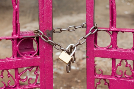 Close up chain locked on pink color fence gateの写真素材