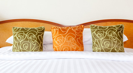 Hotel room setting with king sized bed, Thai silk orange and green pillows in Thailand hotelの写真素材