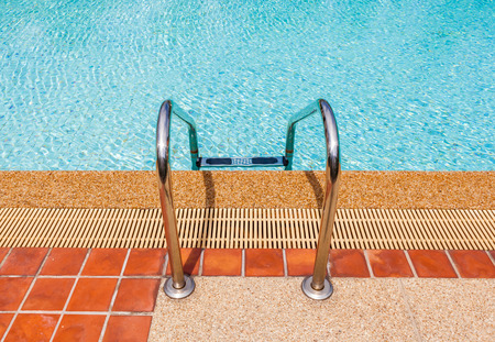 Grab bars ladder in the blue swimming poolの写真素材
