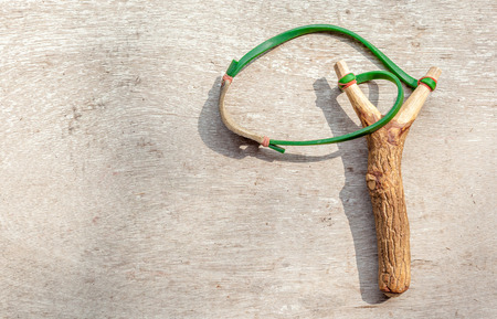 The old slingshot on old wood backgroundの写真素材