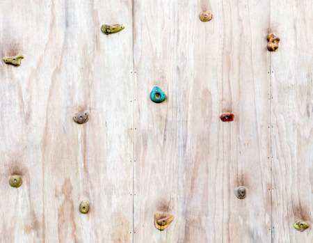 The wood surface of an artificial rock climbing wall with hand and toe hold studs, adventure and extreme sport activity.の写真素材