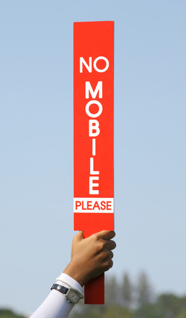 The no mobile sign was held up by volunteer in golf tournament, before starting the game.の写真素材
