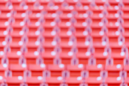 Abstract blurred background of red seats at football stadium.