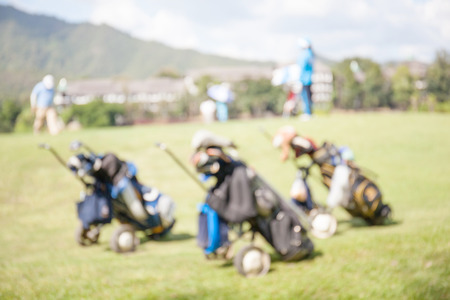 Blurred photo of golf bags over the green field background, in golf tournament.の写真素材