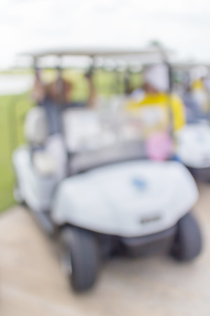 Blurred photo of caddy with golf cart parks around golf course service standby for golfers.の写真素材