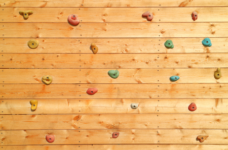 The wood surface of an artificial rock climbing wall with hand and toe hold studs, adventure and extreme sport activity.の写真素材