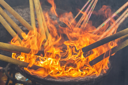 Lighting up the joss stick with fire flames. Asian traditional religion for the Good luck.の写真素材
