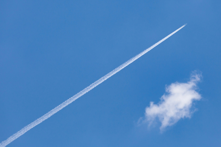 The airplane trail speed through cleared blue sky.の写真素材