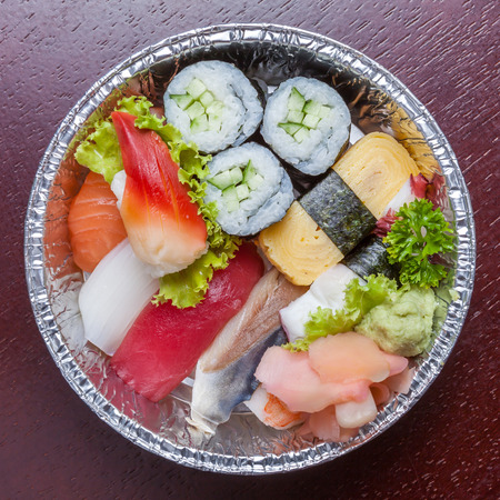 Top view of bento aluminum box, mixed nigiri and assorted sushi roll in lunch box.の写真素材
