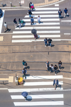 Hakodate, Hokkaido, Japan- June 9, 2016. People crossing the junction while tram parked at station.のeditorial素材
