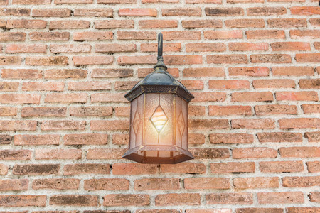 Exterior vintage wall lamp illuminated on brick wall building.の写真素材