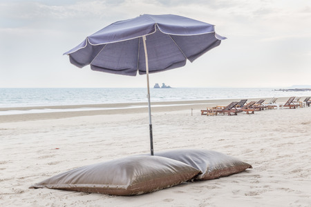 Comfortable beach chairs and umbrella on the white sand beach in evening time, relaxation and vacation time.の写真素材
