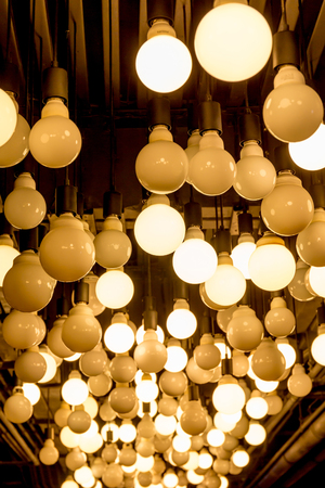 Group of Edison light bulbs hanged from ceiling in department store.の写真素材