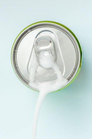 Top view of white soda foam splashing over the aluminum beverage can.の写真素材