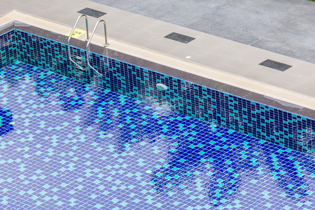 The view of metallic ladder entrance to clear blue swimming pool.の写真素材