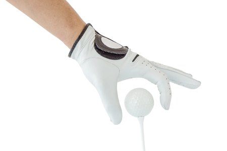 Golfer hand in white glove action with golf ball on tee with white background, golf sport concept.の写真素材