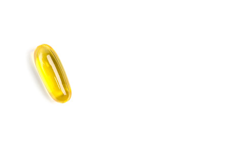 A golden soft gel capsule on white background, natural fish oil supplements.(right space for text)の写真素材