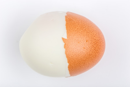 Half peeling of hard shell boiled egg isolate on white background.の写真素材