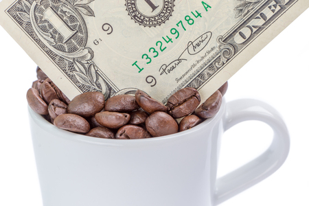 Detail of one US dollar banknote in a cup of coffee beans on white background.の写真素材