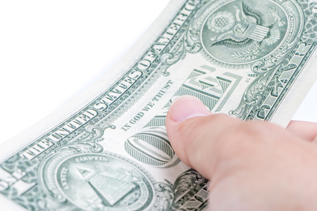 A man hand paying one US dollar bills on white background, business and finance concept.の写真素材