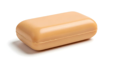 A single, plain bar of beige-colored soap is isolated on a clean white background with a soft shadow. This minimalist product shot effectively communicates concepts of cleanliness, hygiene, personal care, and simplicity.の素材