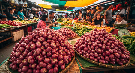 A vibrant and busy outdoor food market, likely in Southeast Asia, with vendors and shoppers. The foreground features large woven baskets piled high with fresh red onions, showcasing local culture and fresh produce.の素材