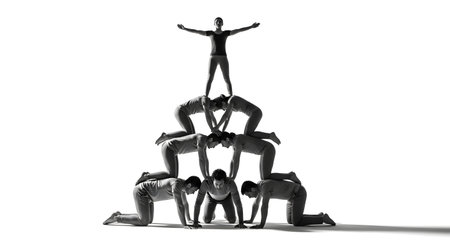 A black and white studio shot of a group of acrobats or dancers forming a human pyramid. The composition demonstrates teamwork, balance, and strength, with a woman standing at the top with arms outstretched.の素材