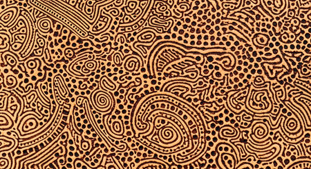 A macro-detail shot of an intricate, abstract pattern resembling indigenous or Aboriginal art. Dark brown lines, spirals, and dots are carved or printed onto a textured, light brown surface, possibly leather or cork. The design is complex, organic, and fills the entire frame.の素材