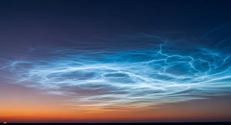 A stunning view of noctilucent clouds (NLCs) glowing electric blue and white, resembling lightning, against a twilight sky. The horizon shows the deep orange and purple colors of a sunset or sunrise.の素材