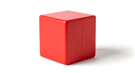 A simple, bright red wooden block with a visible grain texture, shaped as a rectangular prism, stands vertically on a white background. This minimalist object represents basic shapes, building, toys, or a fundamental concept.の素材