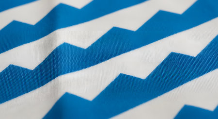 A macro, close-up shot of a fabric with a blue and white chevron or zigzag pattern. The texture of the woven textile is clearly visible, creating a geometric and modern background.の素材