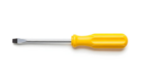 A standard flathead (slot) screwdriver with a yellow plastic handle and a metal shaft. The tool is lying horizontally and is isolated on a clean white background. This image represents tools, DIY, and repair.の素材