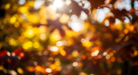 A beautiful abstract background of blurred autumn leaves with golden sunlight shining through. The out-of-focus bokeh creates a warm, dreamy, and natural fall atmosphere.の素材