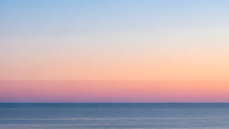 A serene minimalist seascape features a perfectly straight horizon line separating the calm blue ocean from a soft pink and orange sunset sky. The gradient colors create a peaceful, dreamlike atmosphere ideal for background use.の素材