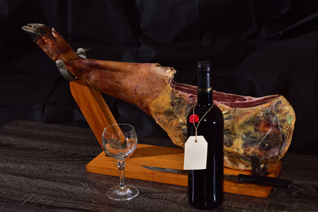 taproom with ham, bottle of red wine and wineglassの写真素材