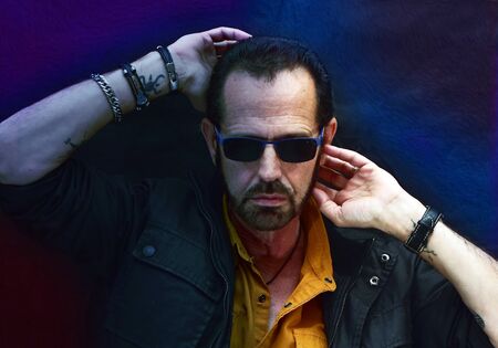 man posing under blue and tattooed lightの写真素材