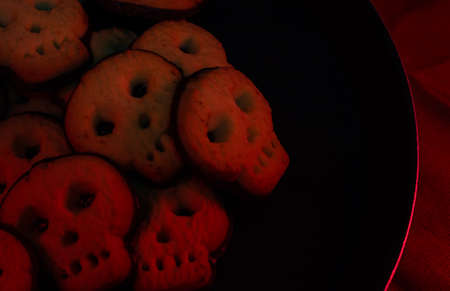 Halloween skull cookies - black background copy space area - horror mood