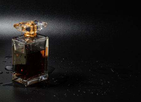 Perfume bottle with water and drops on black background female fresh fragrance, luxury aroma. Empty copy space area.の写真素材