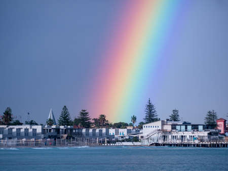 small town on the coast line sea with a real rainbowの写真素材