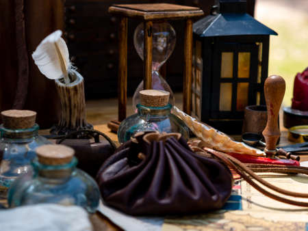 medieval reenactment - scribe's table with goose feather pen, hourglass, sealing wax stamp on a tableの写真素材