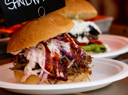 close up of two pulled pork sandwiches with sauces