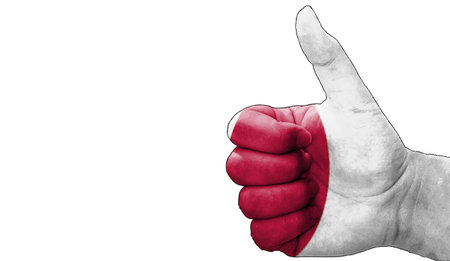 hand with thumbs up in approval with the japan flag painted. Image with empty white background copy space areaの写真素材
