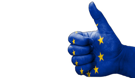 hand with thumbs up in approval with the European Union flag painted. Image with empty white background copy space areaの写真素材