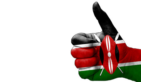 hand with thumbs up in approval with the Kenyan flag painted. Image with empty white background copy space areaの写真素材