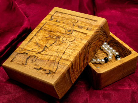 close up shot medieval wooden jewelry box engraved with a pearl necklace inside. Medieval historical jewelry and treasuresの写真素材