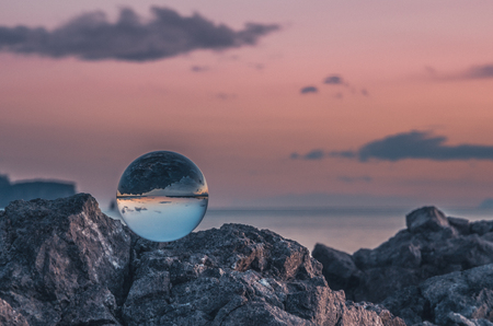 Sunset on the shore of Avacha Bay through a glass ballの写真素材