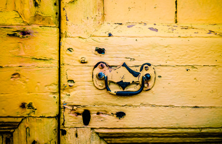 Detail Of Rustic Yellow Front Door With Ornate Handleの写真素材